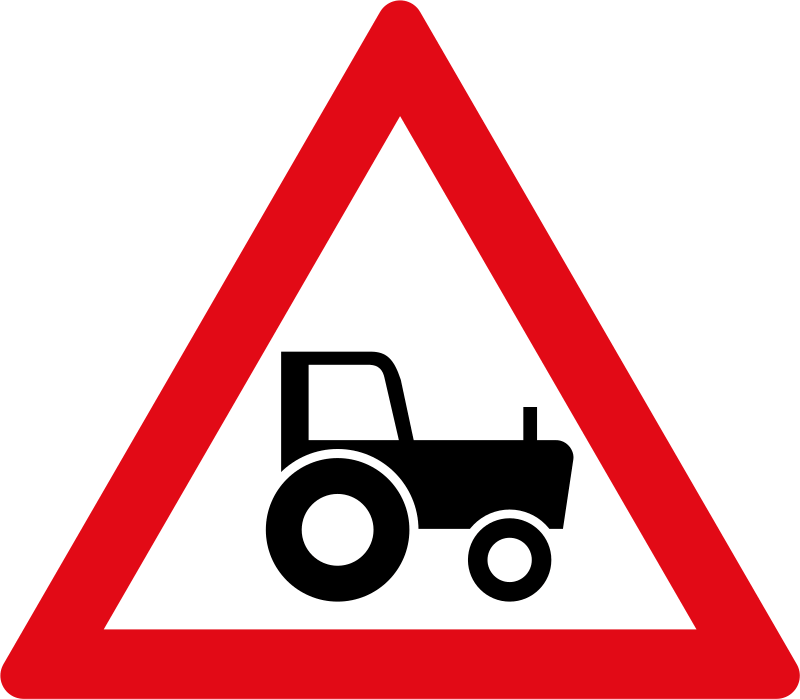 Agricultural vehicles ahead. Slow farm vehicles may be using the road ahead — reduce speed and keep a safe following distance.